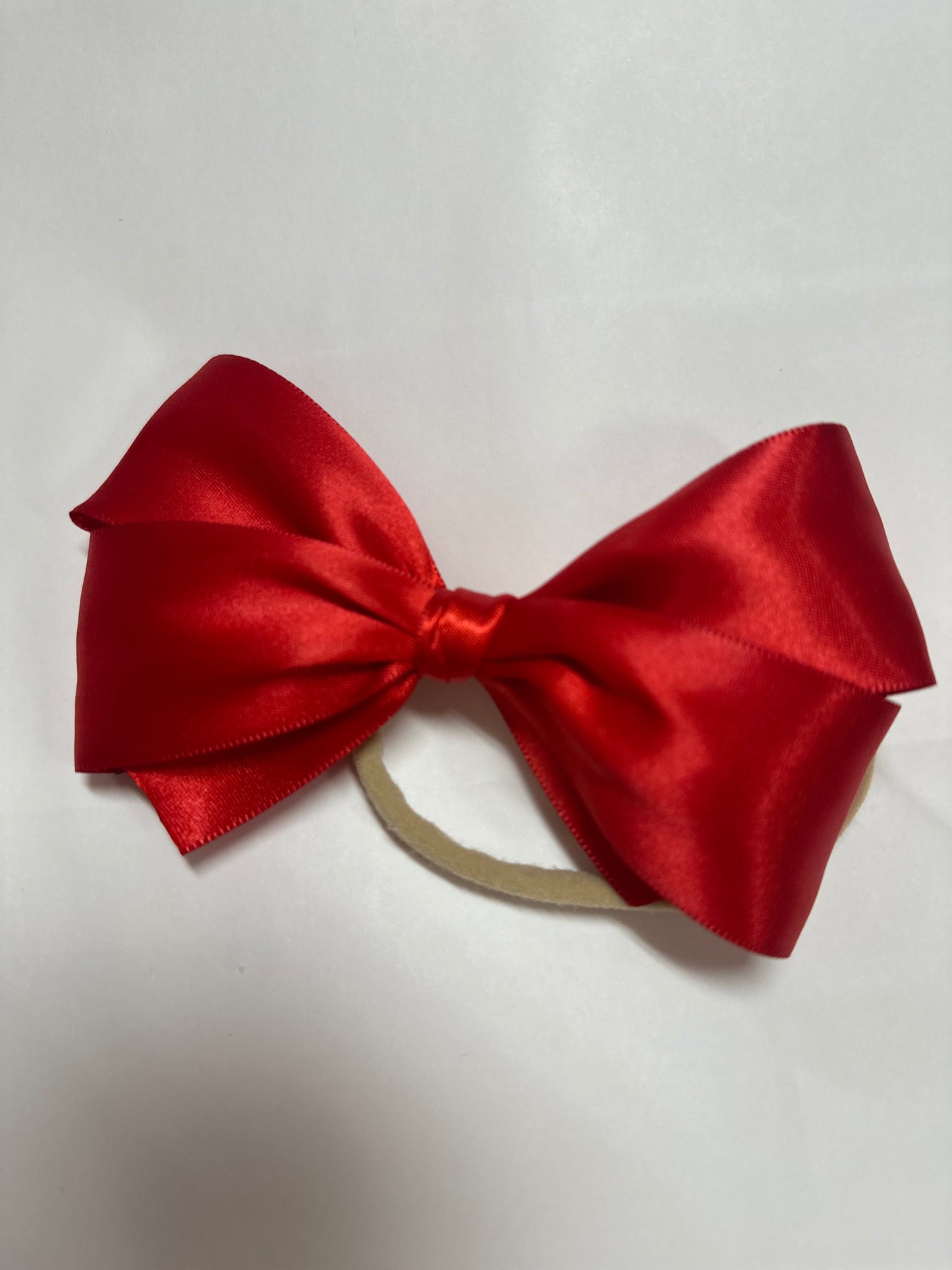 Red satin bow on nylon headband